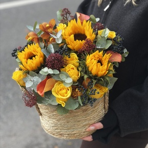 Композиция в сумке "Тональность" из подсолнухов, калл, ягод вибирнума, лимонных роз, скиммии и орхидеи в Рошале