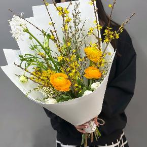 Весенний букет с желтыми ранункулюсами и цветущими ветками форзиции в Рошале