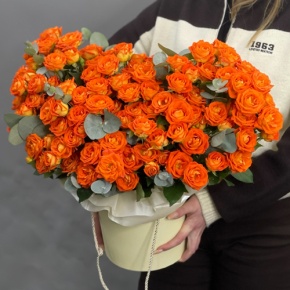 Композиция в шляпной коробке "Закат" из кустовых роз и эвкалипта в Рошале